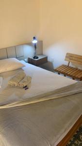 a bedroom with a bed with a lamp and a bench at Casarão 47 in Areia