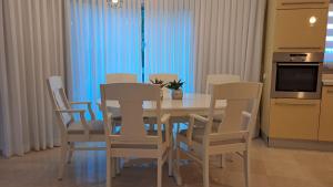 cocina con mesa de comedor y sillas en אבני החושן- Avnei Hoshen en Nahariyya