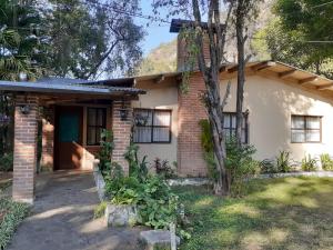 a small brick house with a tree in front of it at Hotel del Bosque Panajachel in Panajachel