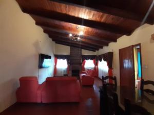 a living room with red furniture and a wooden ceiling at Hotel del Bosque Panajachel in Panajachel