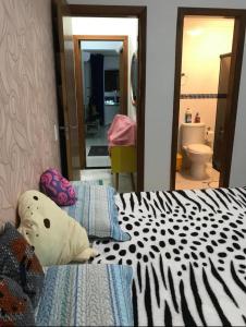 um quarto com uma cama com um edredão preto e branco em Apartamento Cidade Ocian - Praia Grande - Edifício Van Gogh - Alto padrão 94mts - 2 Suítes na Praia Grande