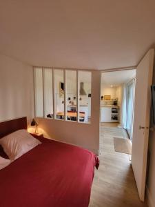um quarto com uma cama vermelha e um espelho grande em L'annexe de la verrerie em Cognac