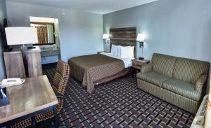 a hotel room with a bed and a chair at Americas Best Value Inn Douglasville in Douglasville