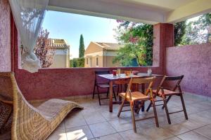 patio con mesa y sillas en el balcón en Best View Apartment 1. en Barbati