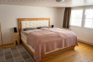 - une chambre avec un lit recouvert d'une couverture rose dans l'établissement Ferienhaus "Hörli" im Toggenburg, à Sankt Peterzell