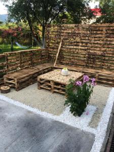 een houten bank met bloemen voor een hek bij Casa la Raisa in Lupeni