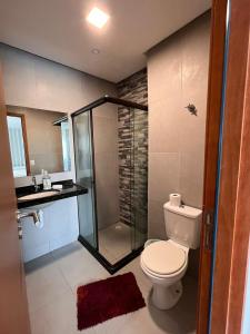 a bathroom with a shower and a toilet and a sink at Condôminio Velas do Porto in Porto De Galinhas