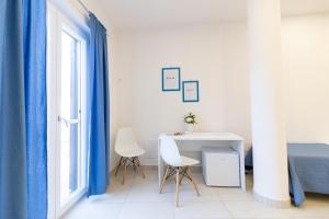 a white table and chairs in a room with a window at B&B MicAnTo - Parcheggio gratuito - Vicino Pompei in Casola di Napoli