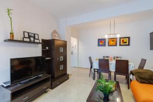 a living room with a television and a dining room at Urban Chic by Fidalsa in Alicante