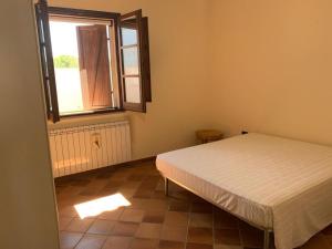 Schlafzimmer mit einem Bett und einem Fenster in der Unterkunft Villetta Girasole in Gallipoli