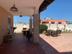 un patio esterno con tavoli, sedie e camino di Villetta Girasole a Gallipoli