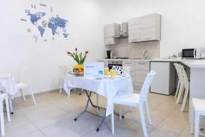 uma cozinha com uma mesa branca e cadeiras e uma cozinha com uma mesa em B&B MicAnTo em Casola di Napoli