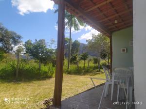 a porch with chairs and a view of the mountains at Encontro dos passaros in Ibicoara