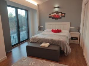 Un dormitorio con una cama con almohadas rojas. en Armada Sacra A Teixeira en Ourense
