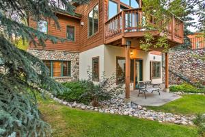 a house with a deck and a bench in the yard at Steamboat Springs Townhome 1 Block to Ski Lifts! in Steamboat Springs