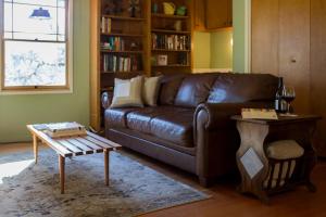 uma sala de estar com um sofá de couro castanho e uma mesa em Bed and Barrel at Stonehouse Cellars em Clearlake Oaks