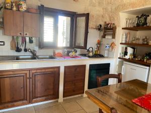 a kitchen with wooden cabinets and a sink and a table at Residenza Di Nonna Giulia in Locorotondo