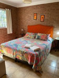 a bedroom with a bed in a brick wall at Departamentos Riosierras in Alta Gracia