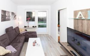 een woonkamer met een bank en een flatscreen-tv bij Residenz Albatros in Cuxhaven