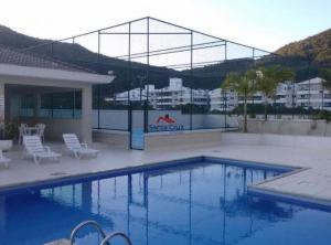 una gran piscina con sillas y un edificio en Apartamento aconchegante próximo ao mar, en Florianópolis