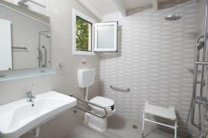 a bathroom with a sink and a toilet and a window at Klonos Anna in Egina