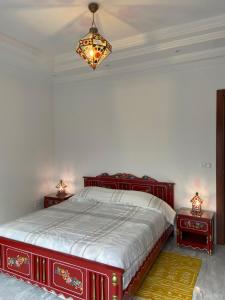 1 dormitorio con 1 cama roja y 2 mesitas de noche en Marsa Authentic Luxury Appart 1, en La Marsa