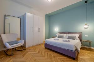 um quarto com uma cama, uma cadeira e um espelho em [DUOMO-PORTA VENEZIA]LUXURY WIFI E NETFLIX em Milão