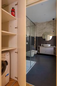 uma casa de banho com um lavatório e uma máquina de lavar roupa em [DUOMO-PORTA VENEZIA]LUXURY WIFI E NETFLIX em Milão