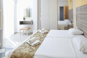 a bedroom with two beds with towels on them at Klonos Anna in Egina