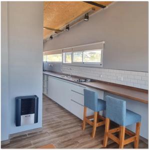 a kitchen with two blue chairs and a sink at Piuquenes 2 in Potrerillos