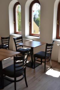 a dining room with tables and chairs and windows at Hostel Děčín Na Skřivánce in Děčín