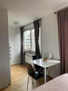 a bedroom with a table and chairs and a window at A charming central one room apartment. in Malmö