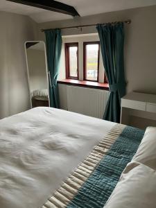 a bedroom with a large bed with green curtains at The Farm House Modern spacious 2 bedroom home at Tong road Leeds perfect for contractors free secure parking in Stanningley