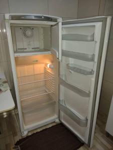 um frigorífico vazio com a porta aberta numa cozinha em Kitnet calma em São José