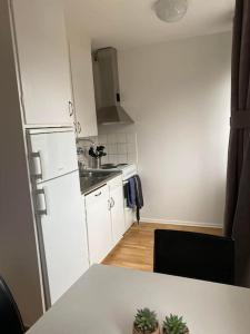 a kitchen with a counter top and a white refrigerator at A charming central one room apartment. in Malmö