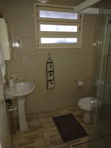 ein Bad mit einem Waschbecken und einem WC in der Unterkunft Kitnet calma in São José
