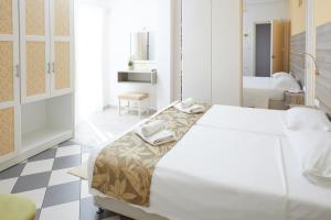 a white bedroom with a bed and a bathroom at Klonos Anna in Egina