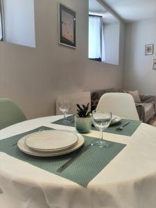 a table with a white table cloth and glasses on it at Proche gare, cosy, courte et moyenne durée in Bellegarde-sur-Valserine