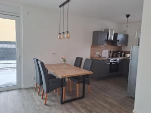 a kitchen and dining room with a wooden table and chairs at Ferienhaus Spreewaldliebe in Lübben
