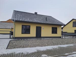 a yellow house with a black door at Ferienhaus Spreewaldliebe in Lübben