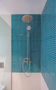 a shower in a bathroom with a blue tiled wall at Gudauri Atrium in Gudauri