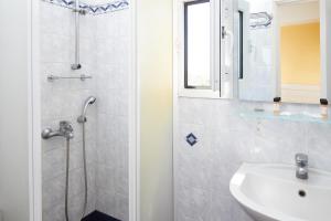 a bathroom with a shower and a sink at Klonos Anna in Egina