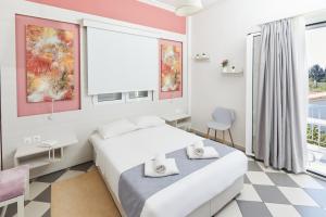 a bedroom with a bed and a large window at Klonos Anna in Egina