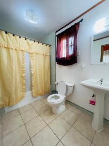 a bathroom with a toilet and a sink at Lamanai Riverside Retreat in Orange Walk