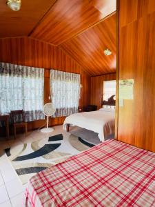1 Schlafzimmer mit 2 Betten und Holzwänden in der Unterkunft Lamanai Riverside Retreat in Orange Walk Town
