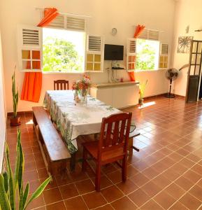 a dining room with a table and benches in a room at <CASA COLIBRI> La Désirade in Les Galets