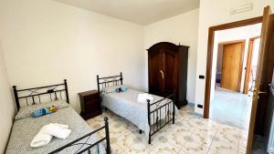 a bedroom with two twin beds and a doorway at Dimora Alma camere panoramiche in Pianillo