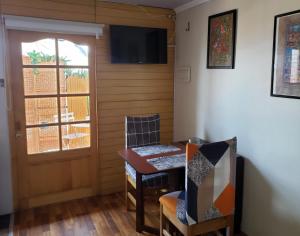 um quarto com uma mesa e cadeiras e uma porta em Un lugar encantador con una pequeña terraza em Iquique