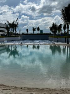 a pool of water with palm trees in the background at Haldis Suites in San Fernando