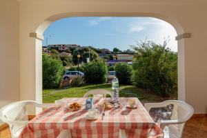 un tavolo con tovaglia a scacchi, sedie bianche e vista di Appartamento sette posti vicino al centro di San Teodoro a San Teodoro